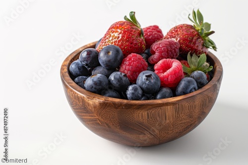 A selection of ripe, juicy berries, including strawberries, blueberries, and raspberries, arranged in a rustic wooden bowl.