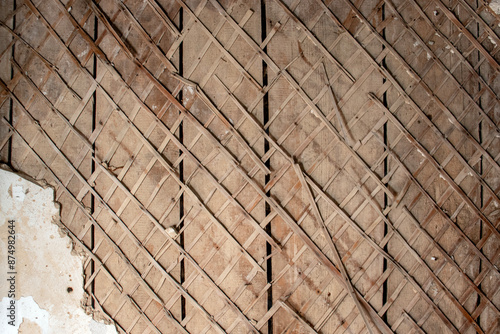 Mesh of slats for plastering the walls of a house. Fragment of the cladding of a wooden wall of an old house. The white plaster had fallen off and exposed the wooden slats of the wall. 
