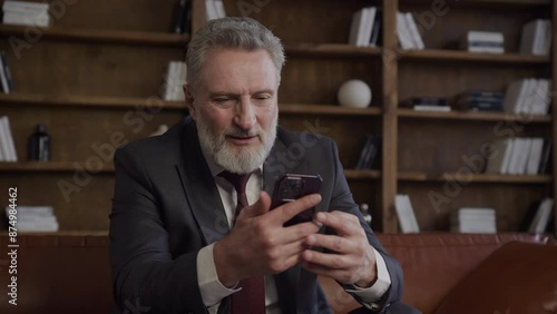 Elderly Man Having a Video Call on Smartphone in Office photo