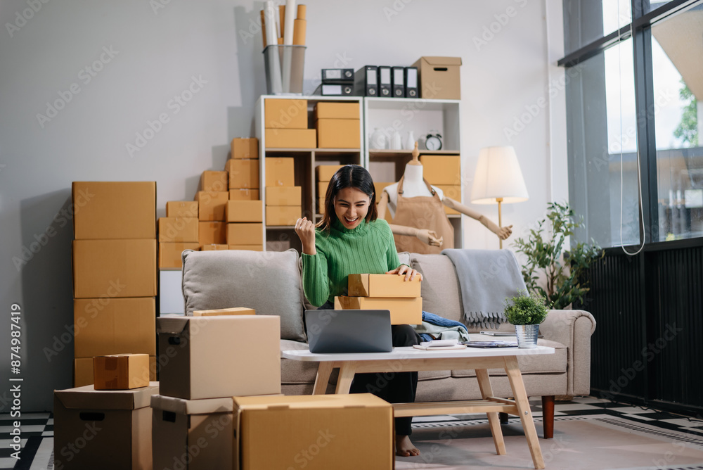 Asian woman prepares parcels and checks online orders on tablet and laptop for delivery online shopping and small business success Asian woman prepares parcels and checks online orders on tablet and laptop for delivery online shopping and small business success