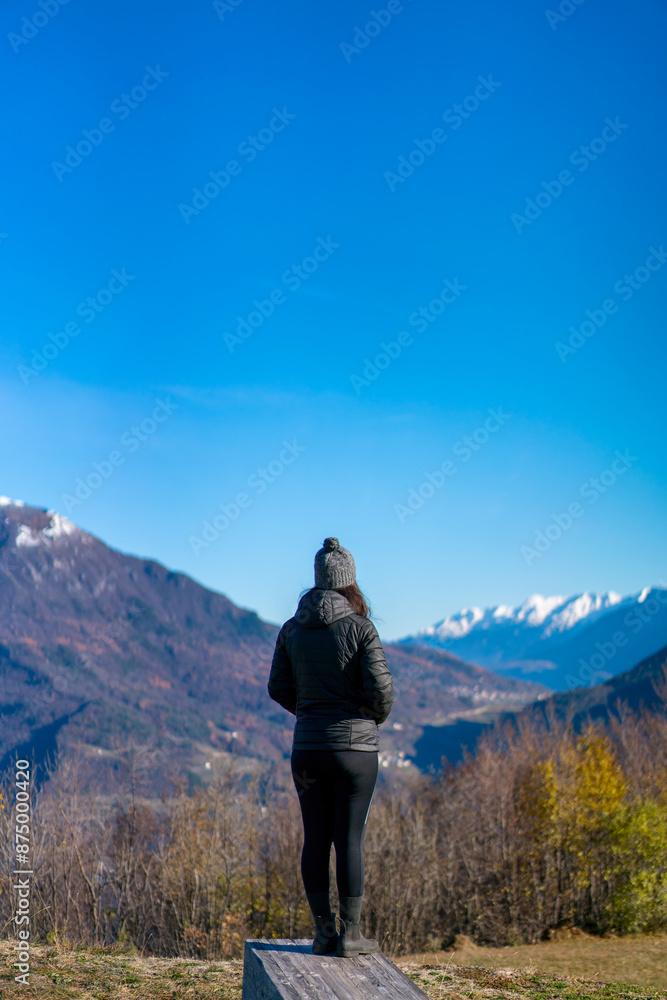 Woman overlooking snowy mountain peaks from hilltop, Italy Woman overlooking snowy mountain peaks from hilltop, Italy