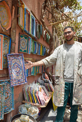 Young craftsman showing proudly his colorful hand-painted decorations