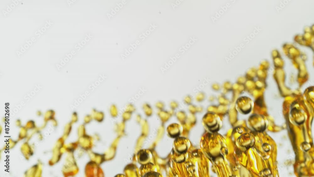Super Slow Motion of Splashing Oil Drops on White Background. Filmed on High Speed Cinema Camera, 1000fps. Abstract Golden Oil Splashes, Beauty or Cooking Concept. Speed Ramp Effect. Super Slow Motion of Splashing Oil Drops on White Background. Filmed on High Speed Cinema Camera, 1000fps. Abstract Golden Oil Splashes, Beauty or Cooking Concept. Speed Ramp Effect.