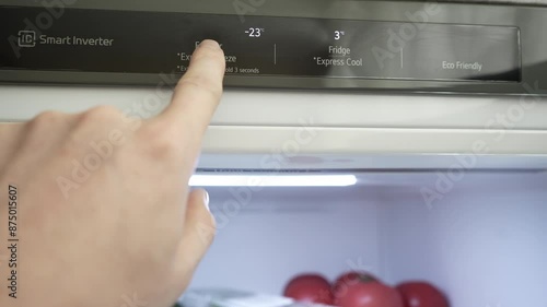 A man's hand regulates the temperature of the refrigerator and freezer. Close-up. Modern gray stylish refrigerator. Optimal food storage temperature. High quality 4k footage