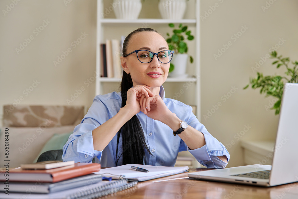 Portrait of business woman sitting at workplace desk with laptop computer Portrait of business woman sitting at workplace desk with laptop computer