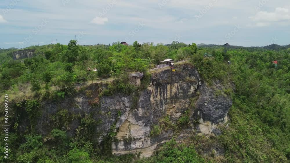 Drone view of a person doing bungee jumping from the cliff of the mountain in Danao Bohol, Philippines. With the mountainous view over the top of the mountains. Drone view of a person doing bungee jumping from the cliff of the mountain in Danao Bohol, Philippines. With the mountainous view over the top of the mountains.