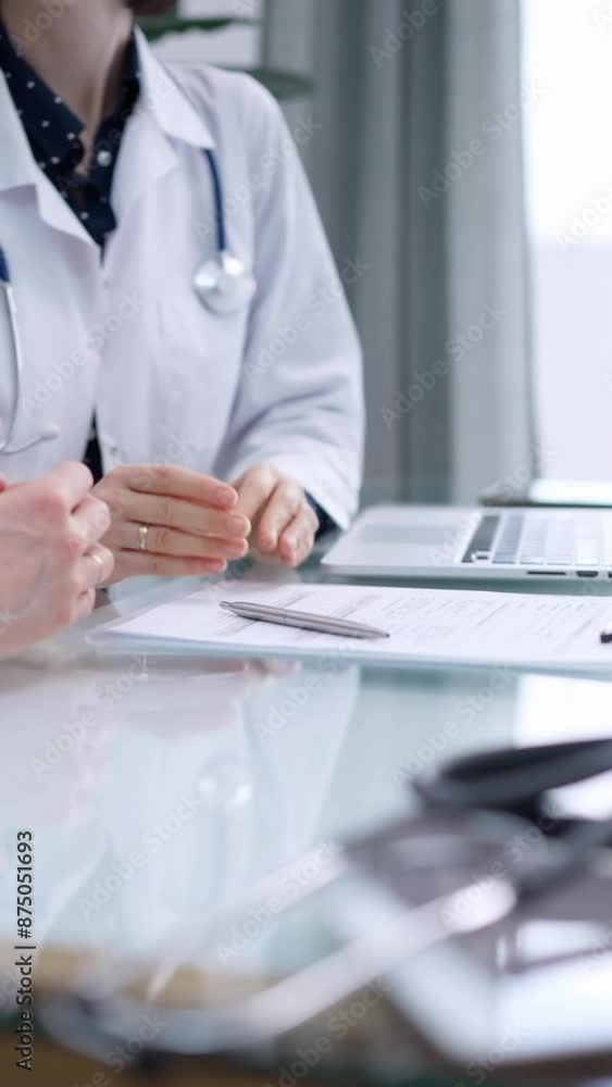 Doctor and patient are talking in clinic. Female physician is sitting at the glass table, listening a senior man. Medicine and pharmacy Doctor and patient are talking in clinic. Female physician is sitting at the glass table, listening a senior man. Medicine and pharmacy