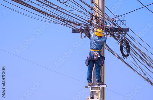 Фотография Electrician with safety equipment on ladder is installing receiving antenna for connection and disconnection electrical current system on electric power pole