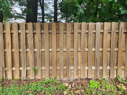 Wooden fence with alternating panels. Privacy fence in backyard.