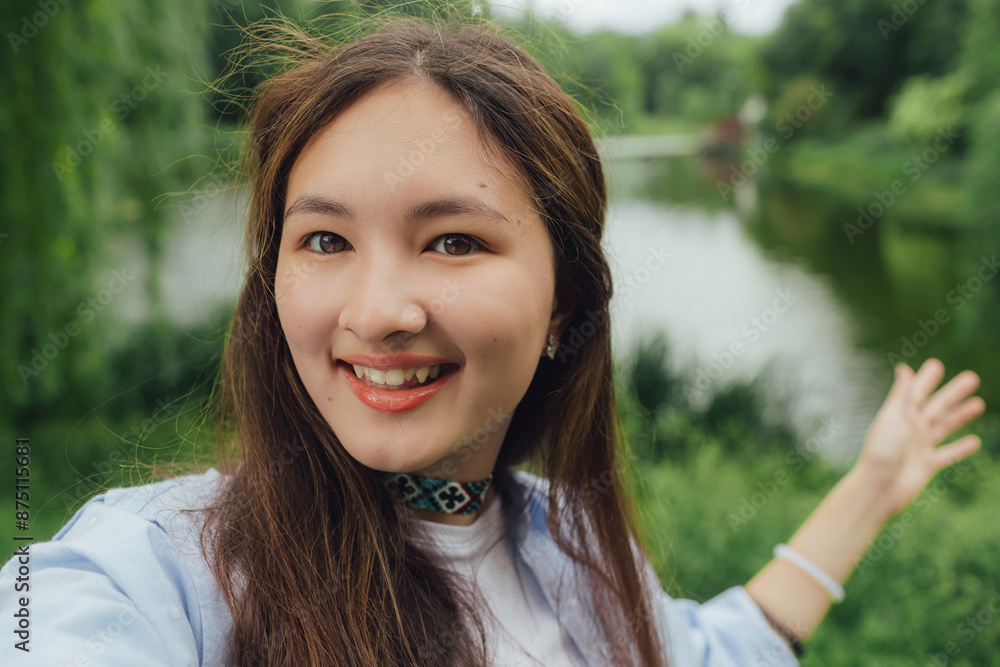 Korean girl with phone and 5g network outdoor for communication, social media and reading news app in summer park. Lady taking selfie. Unity with nature, sport yoga concept. Part of the series