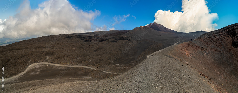 Arid and desert views along the sides of the Etna volcano, with ancient lava flows and effusive rocks on the mountain ridges and secondary craters