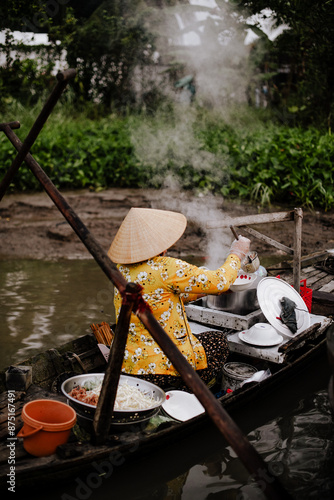 A Vietnamese woman selling pho on the Phong Dien floating market in Vietnam
