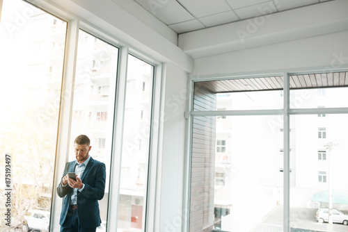 Business, empty office and man with smartphone for email or communication and networking. Entrepreneur, property and serious for online or digital application with funding for startup company © peopleimages.com