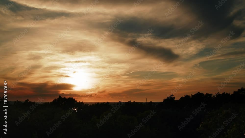 Landscape with sunset and clouds Time lapse.Sun slowly sets below horizon passing between clouds.Sunset over the hills, clouds gently drifting across the sky, creating an enchanting and serene picture Landscape with sunset and clouds Time lapse.Sun slowly sets below horizon passing between clouds.Sunset over the hills, clouds gently drifting across the sky, creating an enchanting and serene picture
