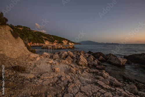 Hidden bay in sunrise. Looked at the small sand, pebble, beach in warm colors and the morning light. View of the sea at Xigia Sulfur Beaches, Ionian Islands, Greece photo