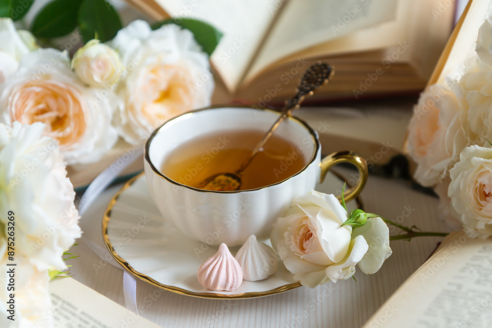 A cup of aromatic tea, a book and a rose on the table. May June July August. A cup of aromatic tea, a book and a rose on the table. May June July August.