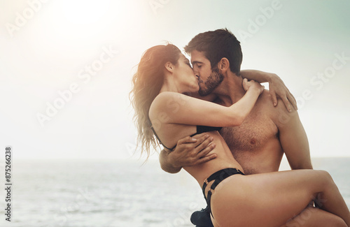 Couple, romance and kiss on beach for love, travel and fun date adventure in summer with bikini. Man, woman and intimate outdoor for holiday, happiness and commitment with hug, flare and connection