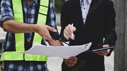 Foto Close-up of a foreman and manager reviewing construction plans on-site, using a
