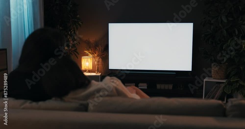 Happy young girls women night evening. Two friends sitting in the living room on sofa gouch relaxing watching tv movie films tv with white screen mockup at cozy home.