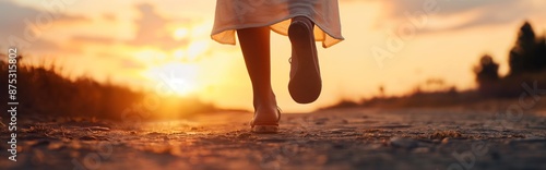 Closeup of woman feet walking in sunset. © armensl