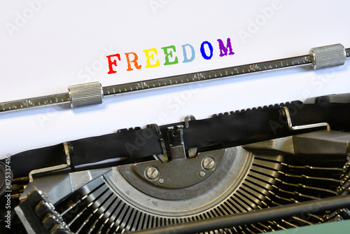 Close up of a vintage typewriter with the text "FREEDOM" in rainbow colors