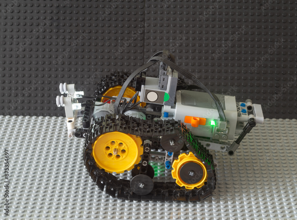 Obraz premium The robot drives on the gray surface.Teaching children robotics using toys.