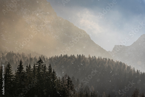 Snow Flakes falling in Golden Light across mountain vista photo