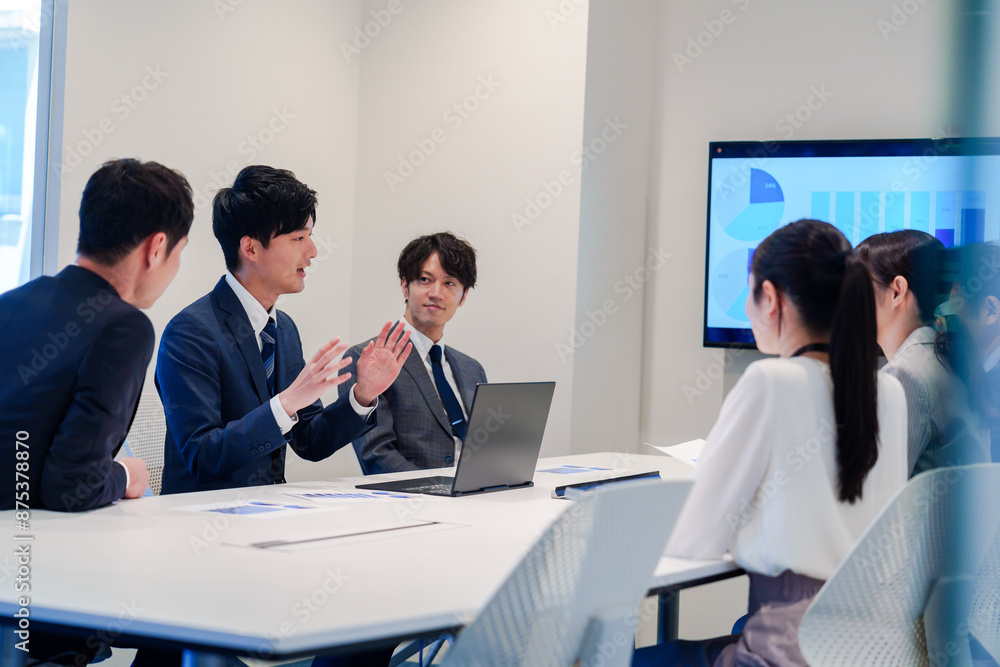 スーツを着て会議で話す若い男性 スーツを着て会議で話す若い男性
