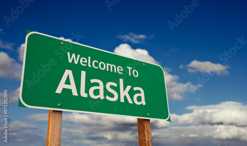 Welcome To Alaska Green Road Sign Over Blue Sky with Some Clouds.