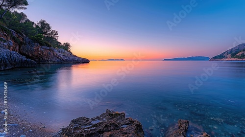 A tranquil bay with calm, shallow waters, the sunset creating a gradient of warm colors across the sky.