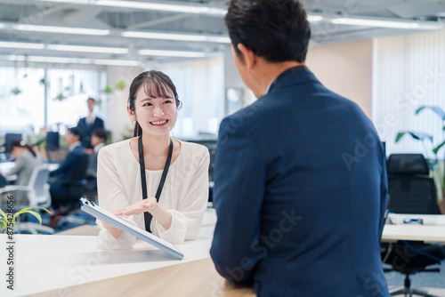Foto 窓口で来客の対応をする女性スタッフ