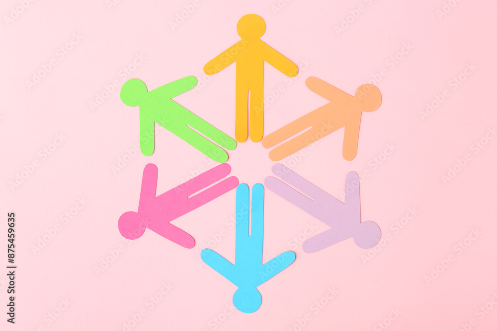 Equality concept. Paper human figures of different colors on pink background, top view Equality concept. Paper human figures of different colors on pink background, top view
