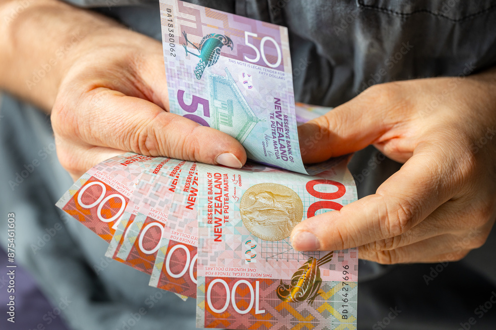 New Zealand money, Man counting New Zealand dollars, Close up of hands with banknotes