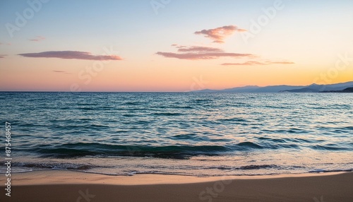 Ethereal pastel sunset over calm mediterranean waters with gentle waves and soft reflections on the sand