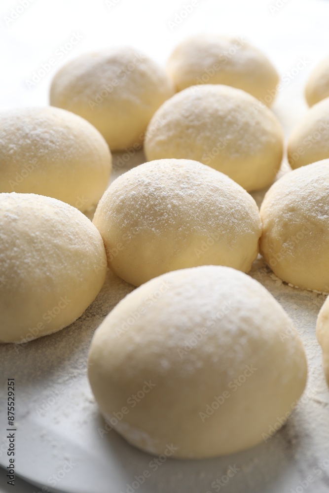 Many raw dough balls with flour on table Many raw dough balls with flour on table