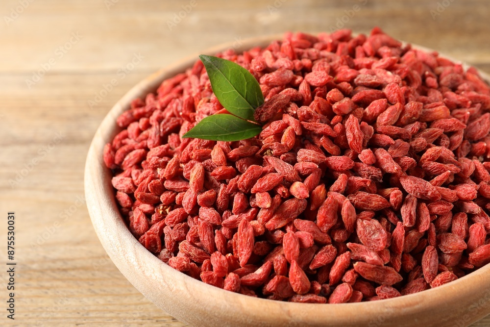 Dried goji berries in bowl on wooden table, closeup Dried goji berries in bowl on wooden table, closeup