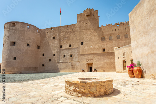 Jabreen citadel fortress stone walls bastions and round well in the yard, Bahla, Oman photo