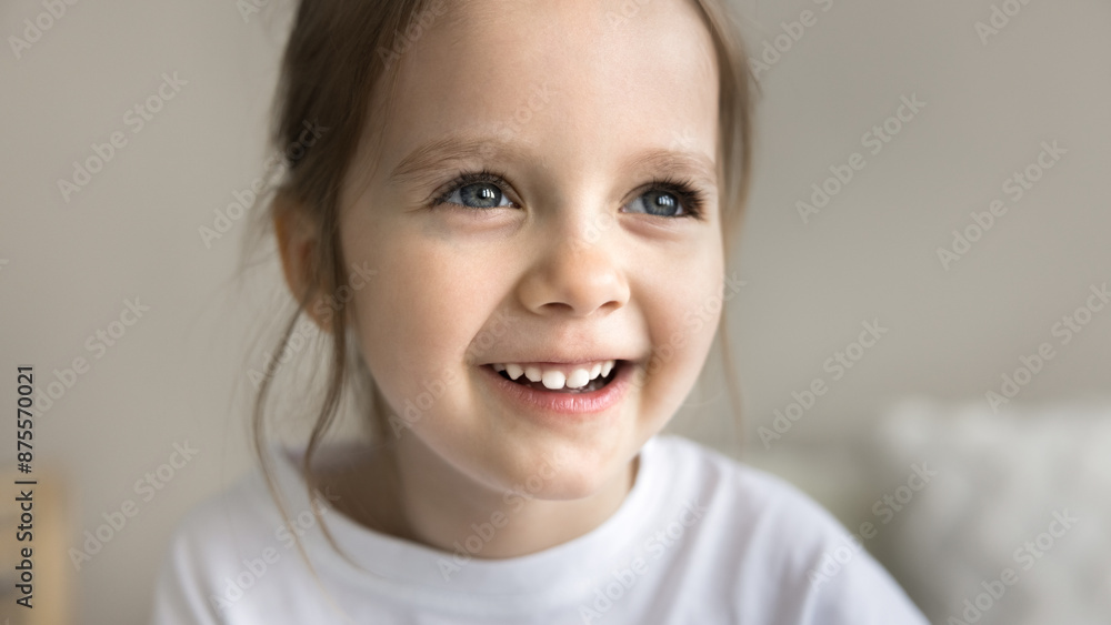 Adorable smiling little 4s baby girl looking away, domestic portrait. Close up face of pretty preschooler child having dreamy positive mood staring into distance in morning at home. Happy childhood Adorable smiling little 4s baby girl looking away, domestic portrait. Close up face of pretty preschooler child having dreamy positive mood staring into distance in morning at home. Happy childhood