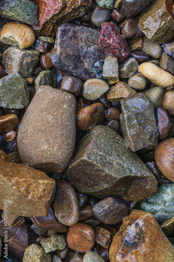 These are wet river pebbles and small round pebbles. Solid background. Top view These are wet river pebbles and small round pebbles. Solid background. Top view