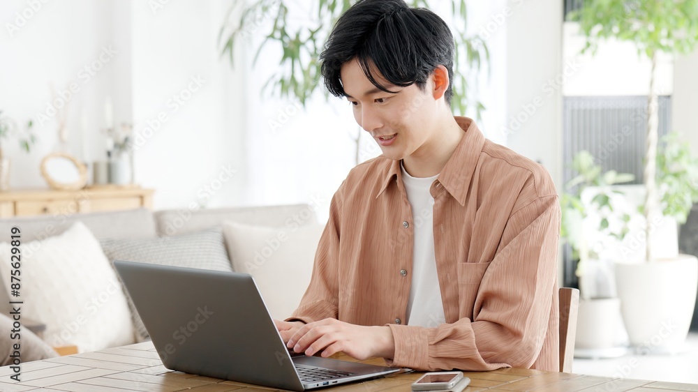 自宅でノートパソコンを使う男性 自宅でノートパソコンを使う男性