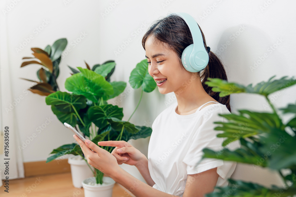 Young Asian woman sitting on the phone after finishing exercise. Young Asian woman sitting on the phone after finishing exercise.