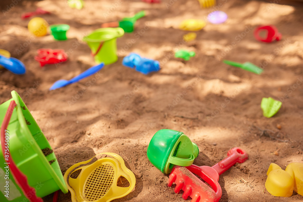 Children enjoying a sunny day in a colorful sandbox filled with toys for a fun and carefree playtime Children enjoying a sunny day in a colorful sandbox filled with toys for a fun and carefree playtime