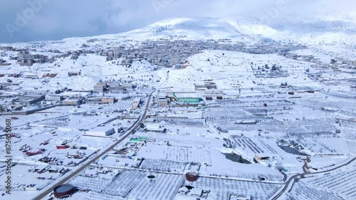 Aerial Forward Beautiful Shot Of Snow Covered Golan Heights Under Cloudy Sky - Majdal Shams, Israel photo