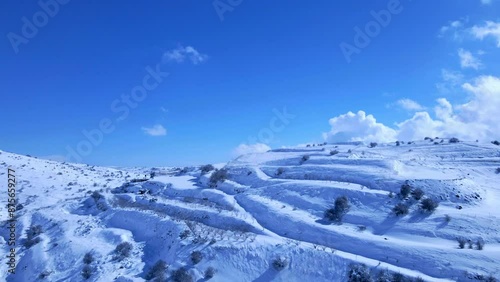 Aerial Backward Panning Shot Of Tranquil Snow Covered Mount Hermon Range On Sunny Day - Majdal Shams, Israel photo