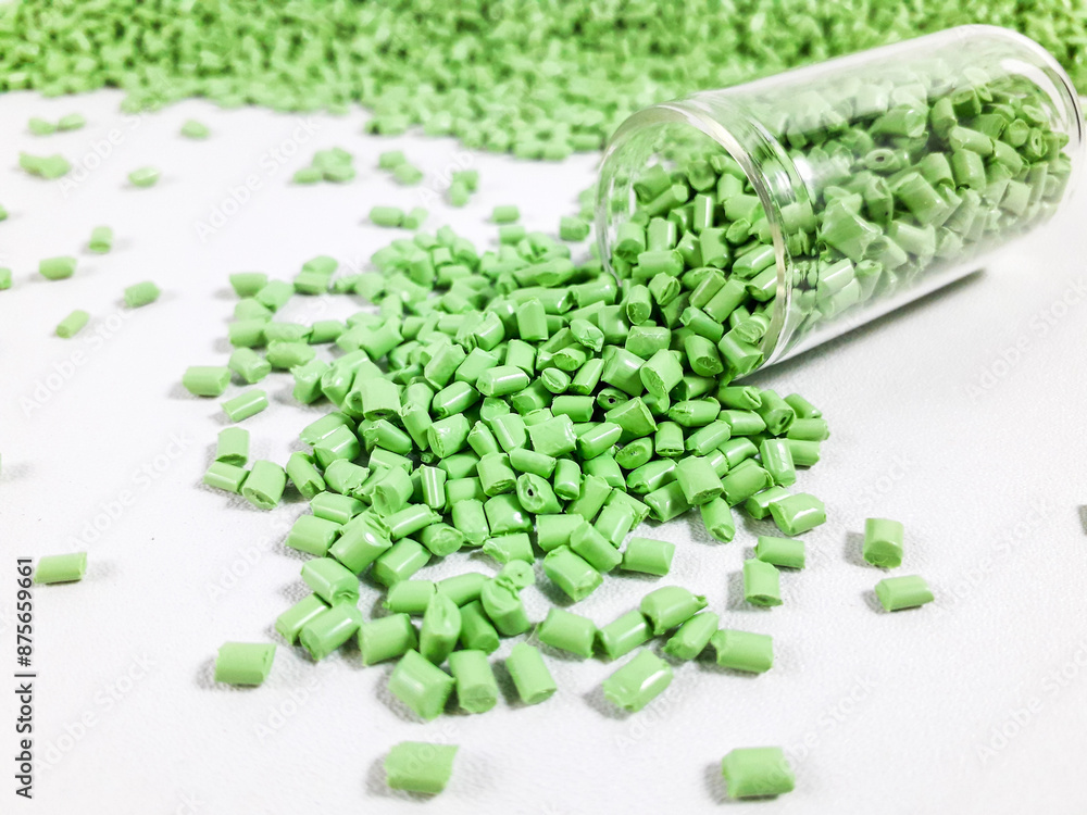 Matcha green masterbatch granules with glass tube on white background.Color pigment carrier polymer in plastic industry Matcha green masterbatch granules with glass tube on white background.Color pigment carrier polymer in plastic industry