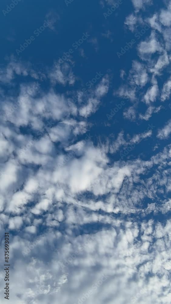 Bottom-up rotating clouds in the blue sky portrait vertical cinematic shot for backgrounds Bottom-up rotating clouds in the blue sky portrait vertical cinematic shot for backgrounds