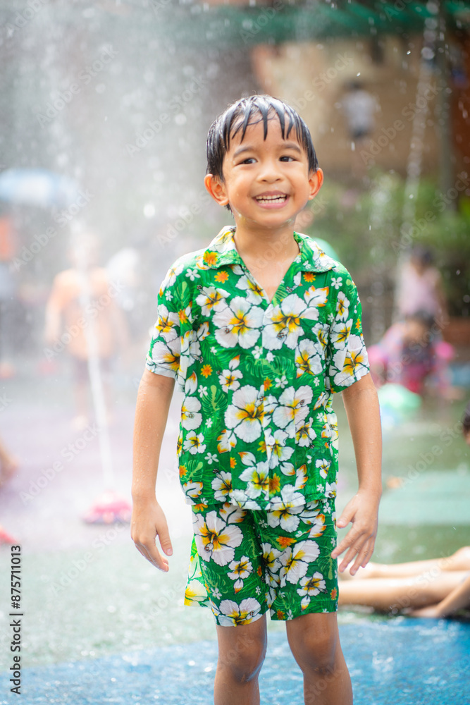 Happy asian kindergarten boy enjoying water splash in aqua park summer vacation Happy asian kindergarten boy enjoying water splash in aqua park summer vacation