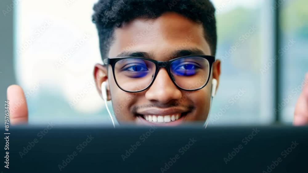 Young adult happy smiling students or businessman wearing headphones talking in online chat meetings using a laptop in an office or campus, male students wear glasses learning remotely Young adult happy smiling students or businessman wearing headphones talking in online chat meetings using a laptop in an office or campus, male students wear glasses learning remotely