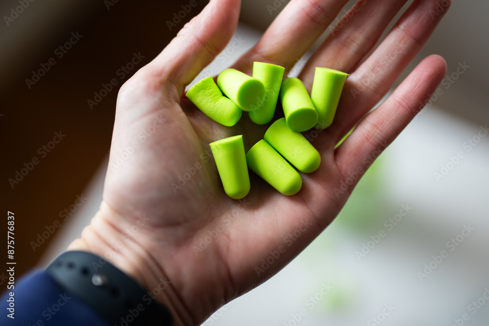 green ear plugs noise reduction sleep quiet jar white background caucasian hand hold green ear plugs noise reduction sleep quiet jar white background caucasian hand hold