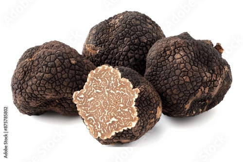 whole black truffles with a few several thin slices arranged around it isolated on a white background.  © Chuemon
